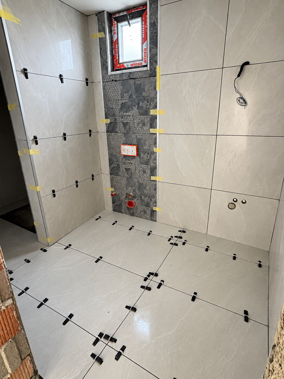 Bathroom shower wall and floor tile installation in progress
